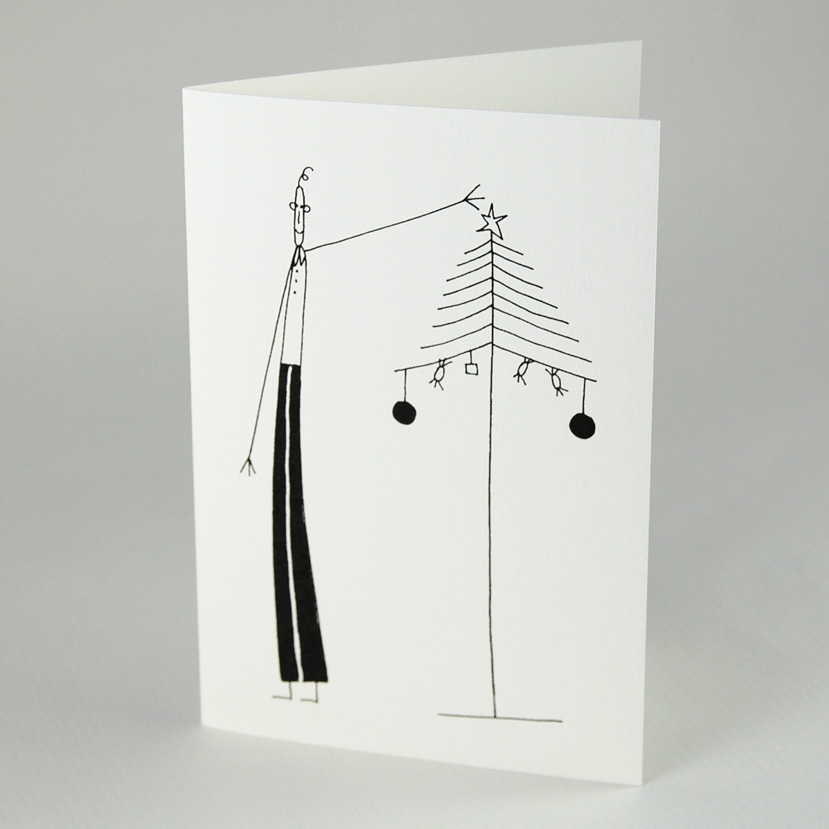Dünner Mann beim Schmücken eines dünnen Weihnachtsbaums, monochrome, schlichte Weihnachtskarten