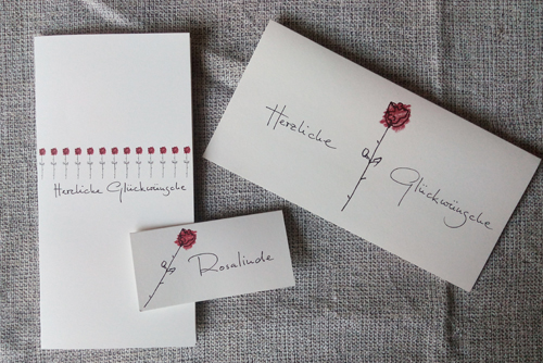schlichte edle Hochzeitseinladungeskarten mit einer einzelnen Rose und handschriftlicher Kalligrafie