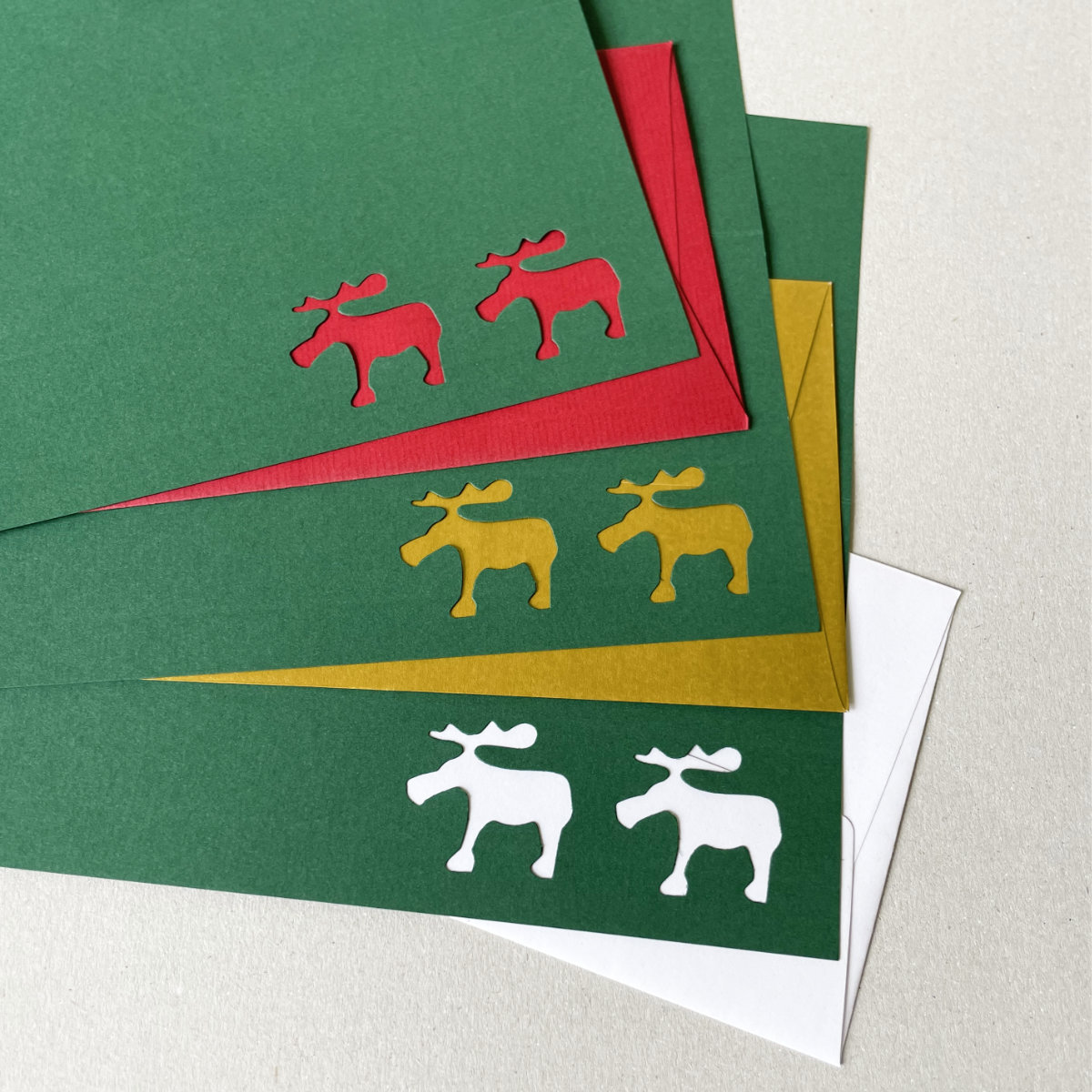 dunkelgrüne Weihnachtskarte mit ausgestanzten Elchen