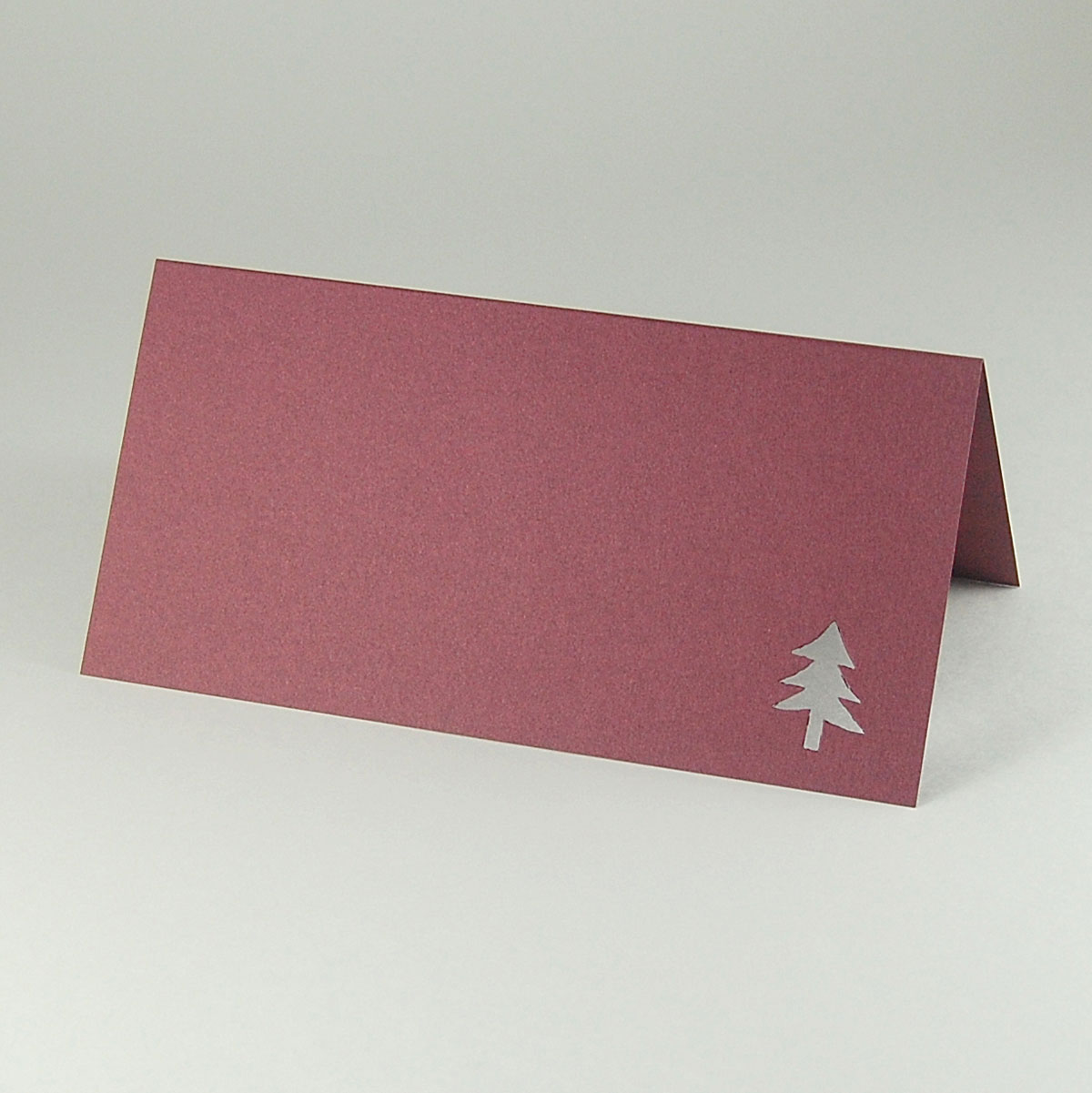 brombeerfarbene Weihnachtskarte mit ausgestanztem Tannenbaum