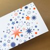 Design-Weihnachtskarten in Firmenfarben mit orangen und blauen Sternen